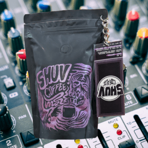 A bag of Shuv coffee set in front of a background of audio mixing equipment